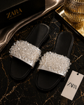 Black slides with silver embellishments on a Zara branded surface