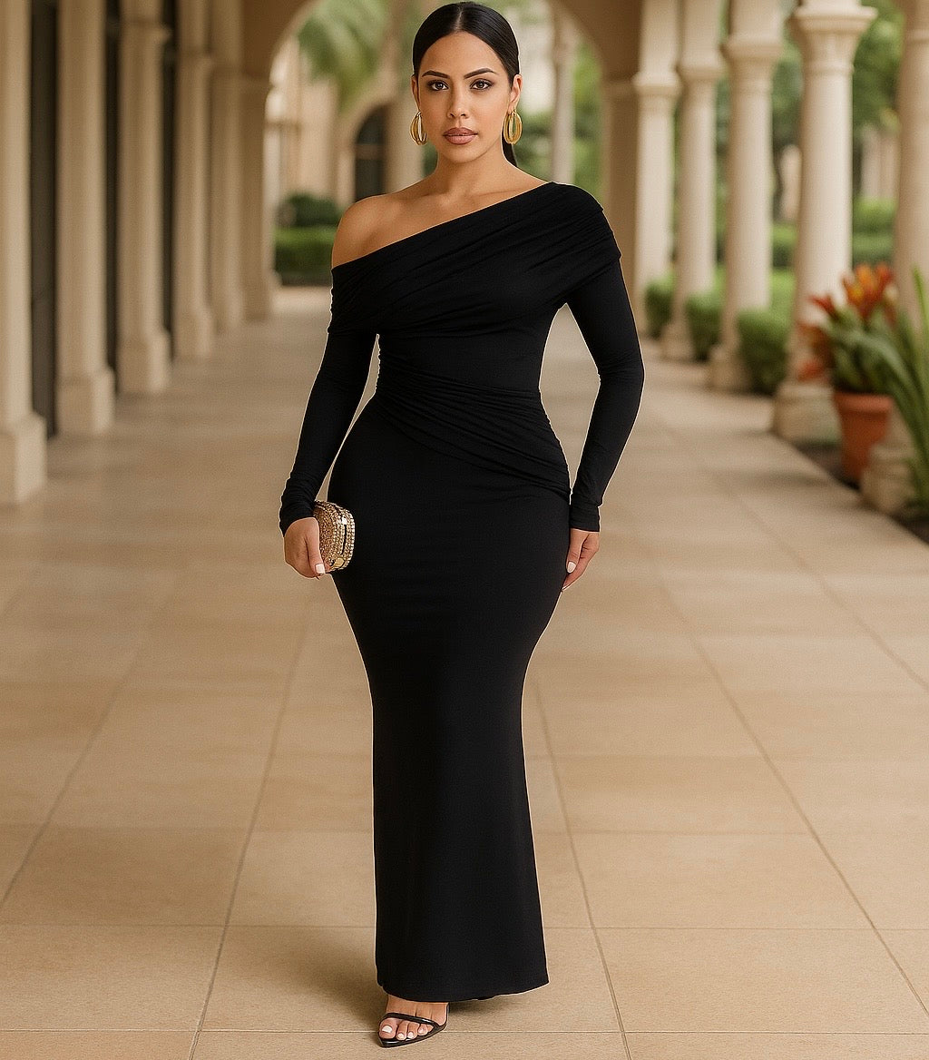 Woman in a black off-shoulder dress standing in an outdoor setting with columns and plants.