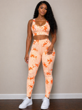 Woman wearing a peach and orange tie-dye athletic outfit against a beige wall.