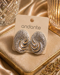 Pair of silver earrings on an 'andante' branded card against a gold fabric background
