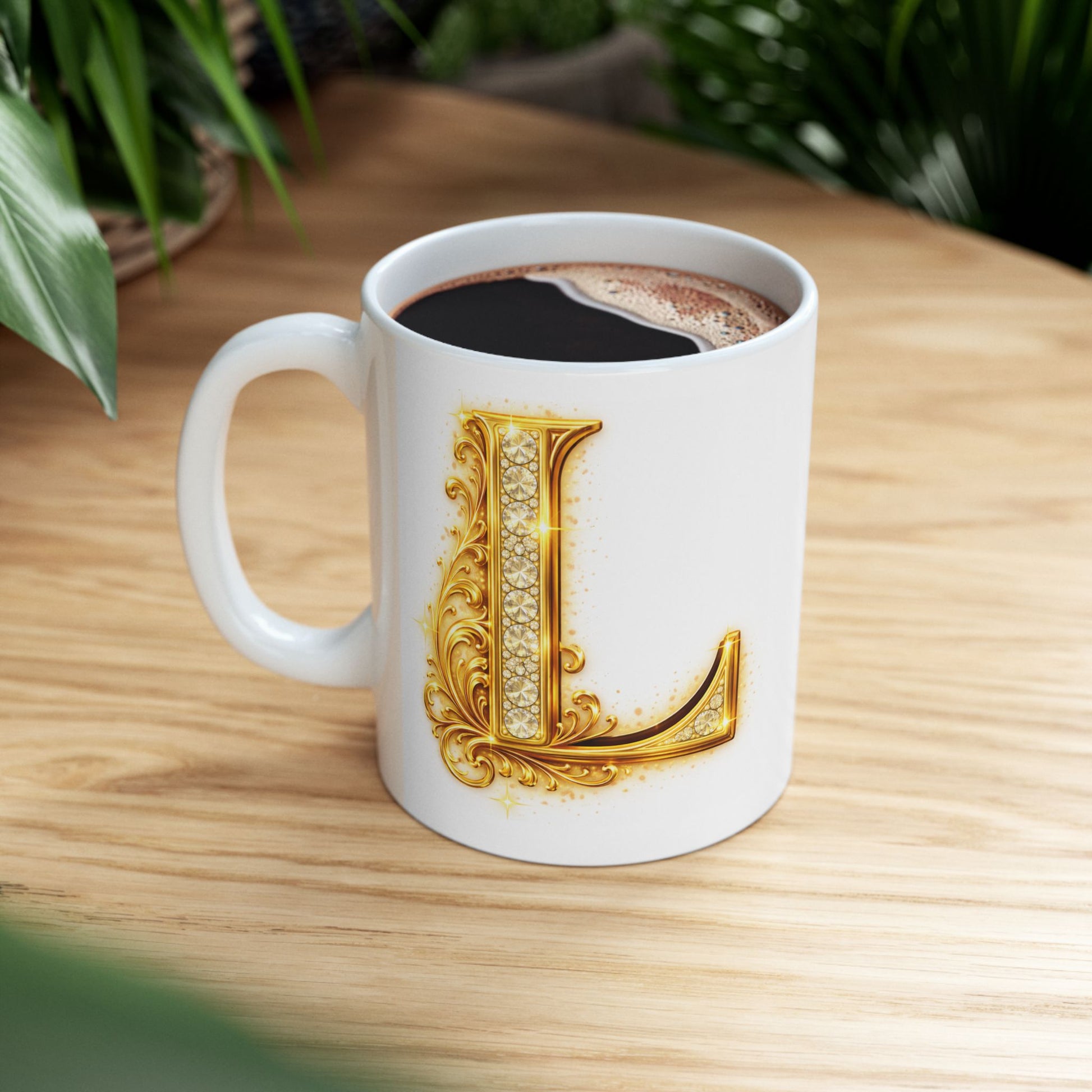 White mug with gold letter 'L' design on a wooden table