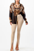 Woman wearing a patterned blouse and beige pants on a white background