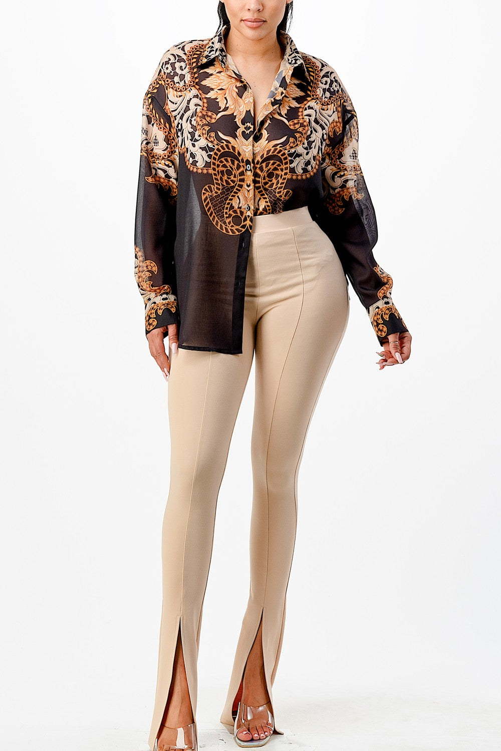 Woman wearing a patterned blouse and beige pants on a white background