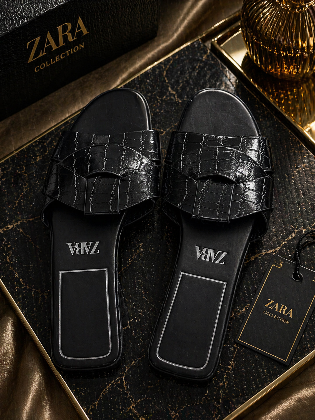 Black crocodile-patterned slides with 'VAMZ' branding on a Zara Collection box.