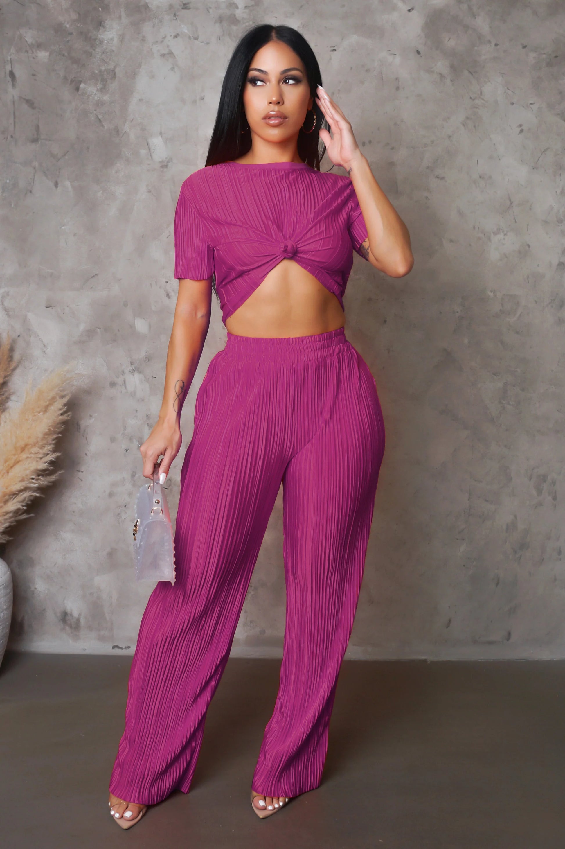 Woman wearing a vibrant pink outfit against a gray background