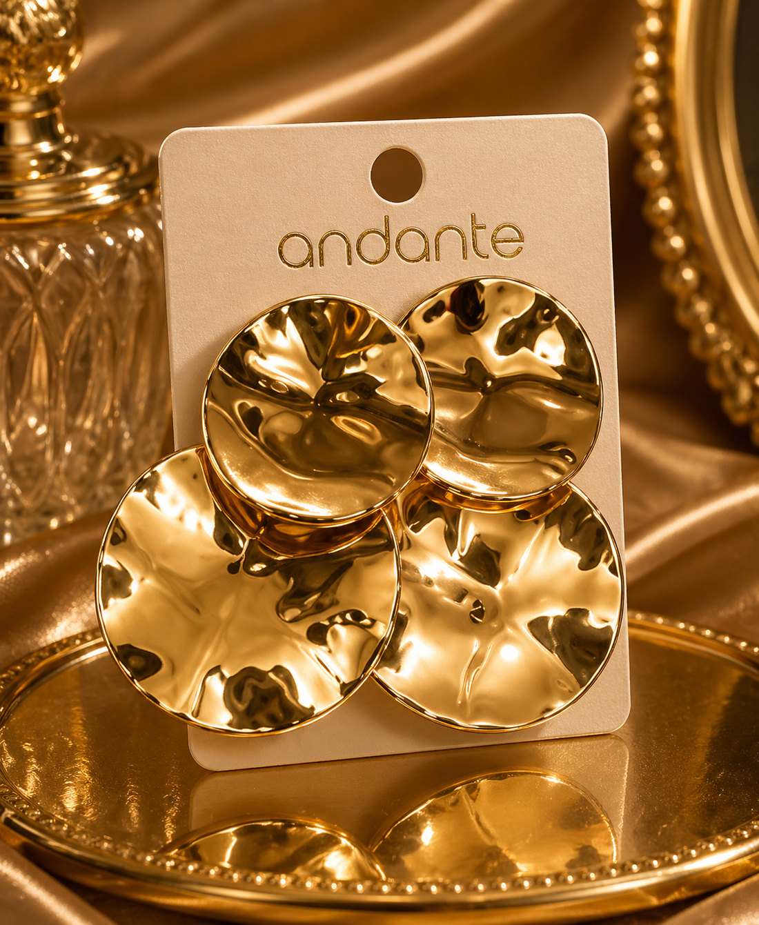 Gold earrings on a 'andante' branded card with a gold background