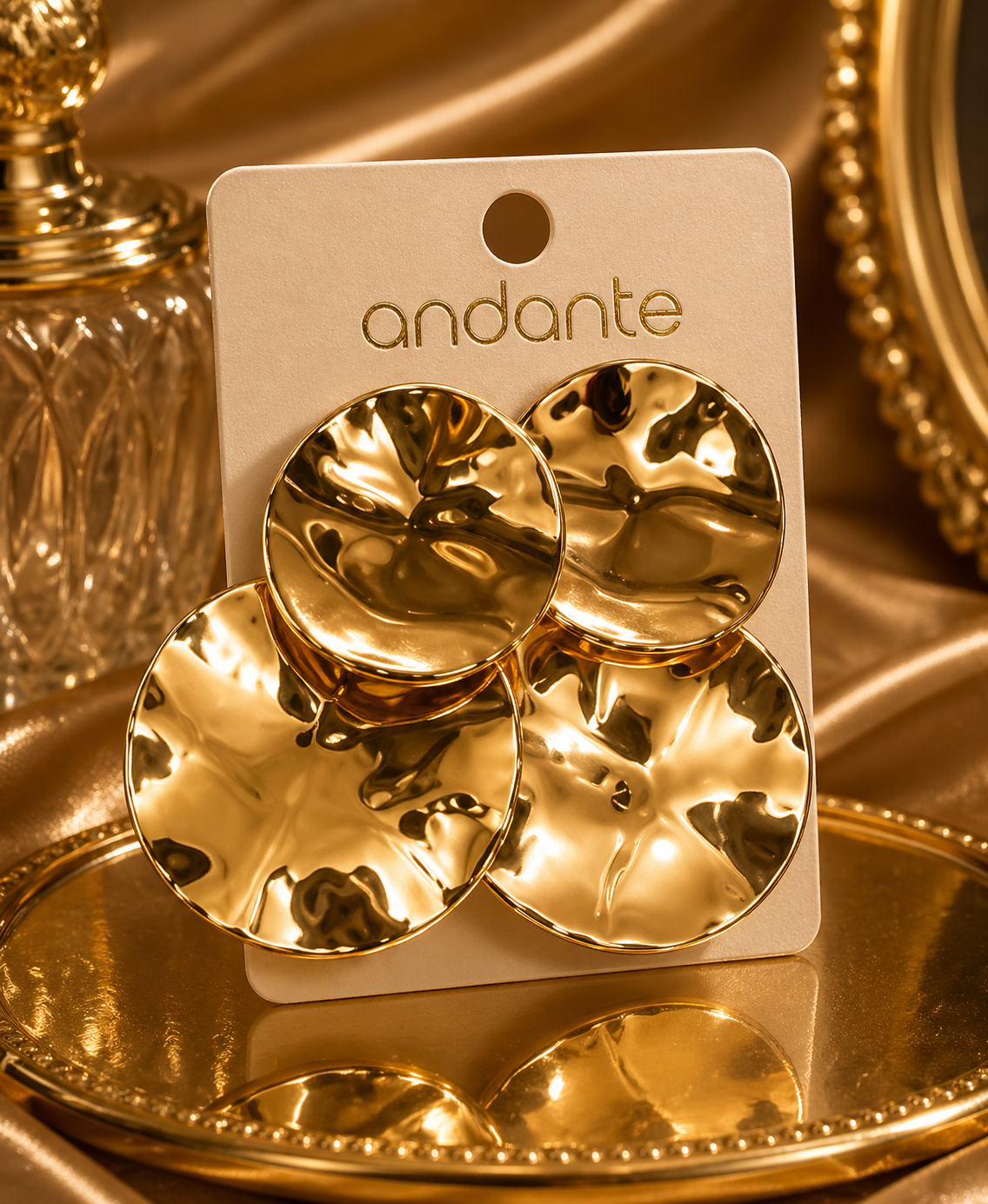 Gold earrings on a 'andante' branded card with a gold background