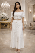 Woman in a white outfit standing in an elegant interior setting