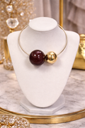 Necklace with large beads on a white marble stand with decorative background