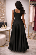 Woman wearing a black dress in a room with decor elements.