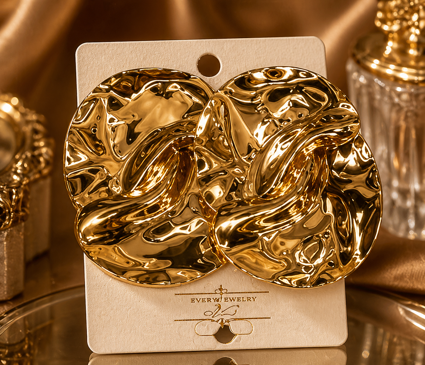 Gold earrings on a branded card with a gold background