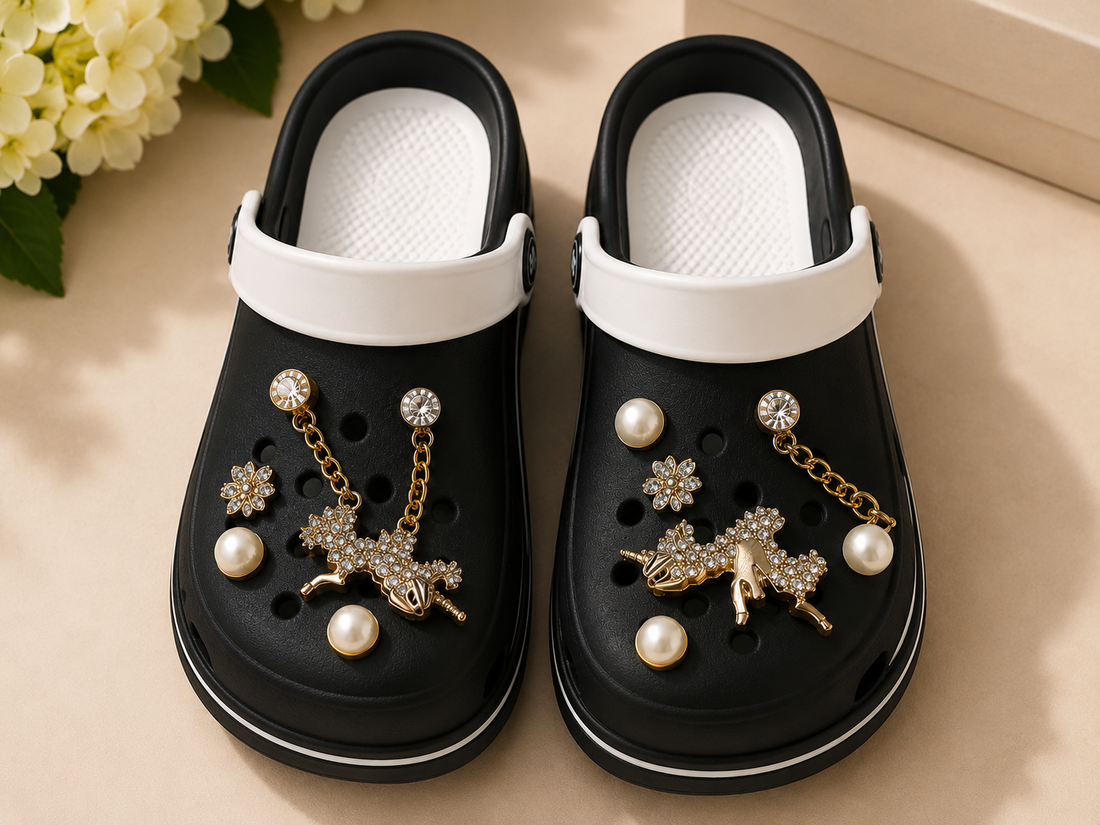 Black clogs with decorative elements on a beige surface with flowers in the background