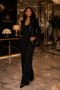 “Woman walking in black suit carrying black Luxe Maison leather crossbody bag in luxury marble lobby”