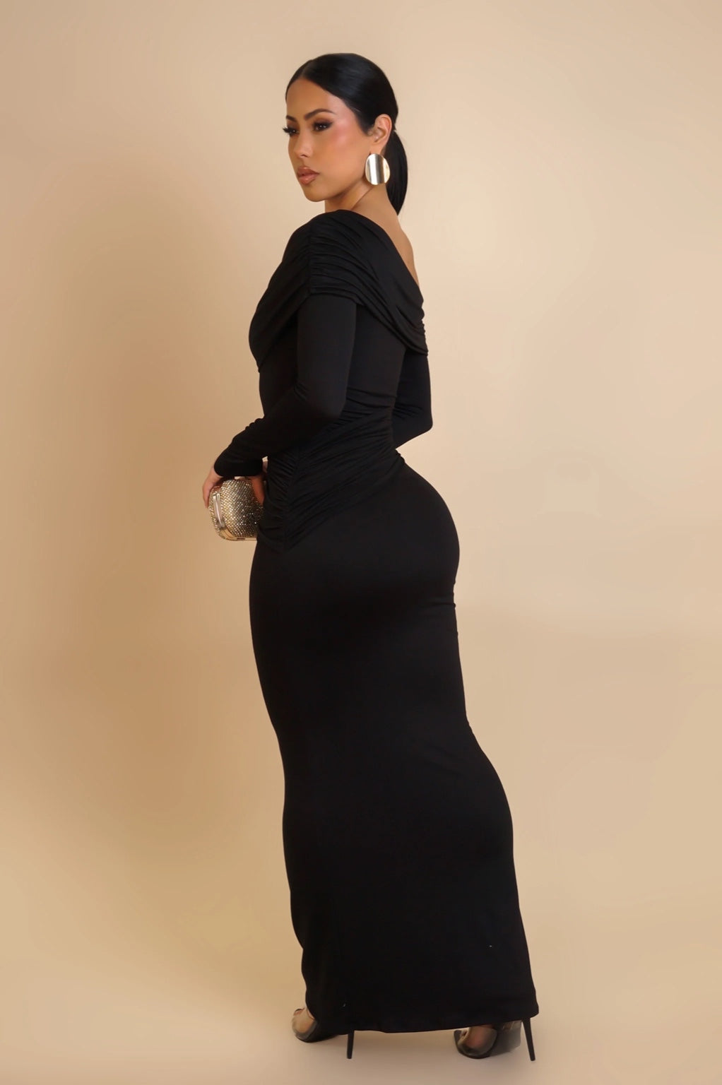 Woman wearing a black evening gown against a beige background