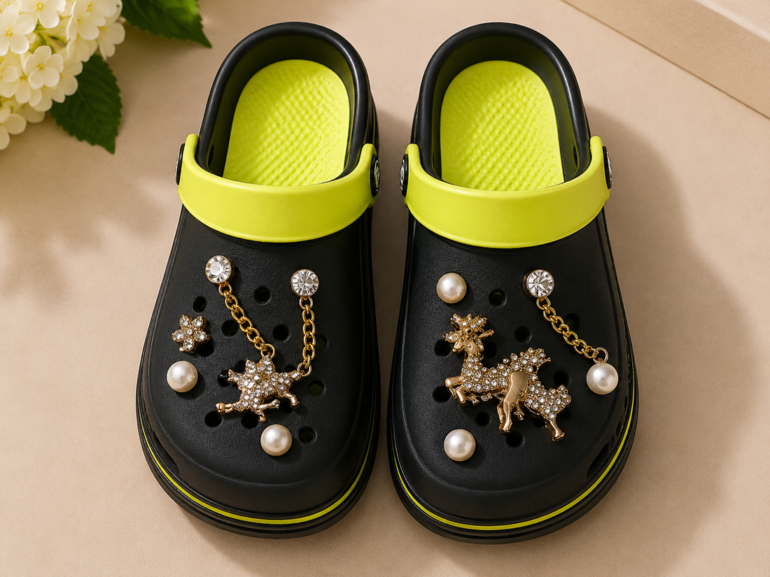 Black clogs with decorative elements on a beige surface with flowers in the background