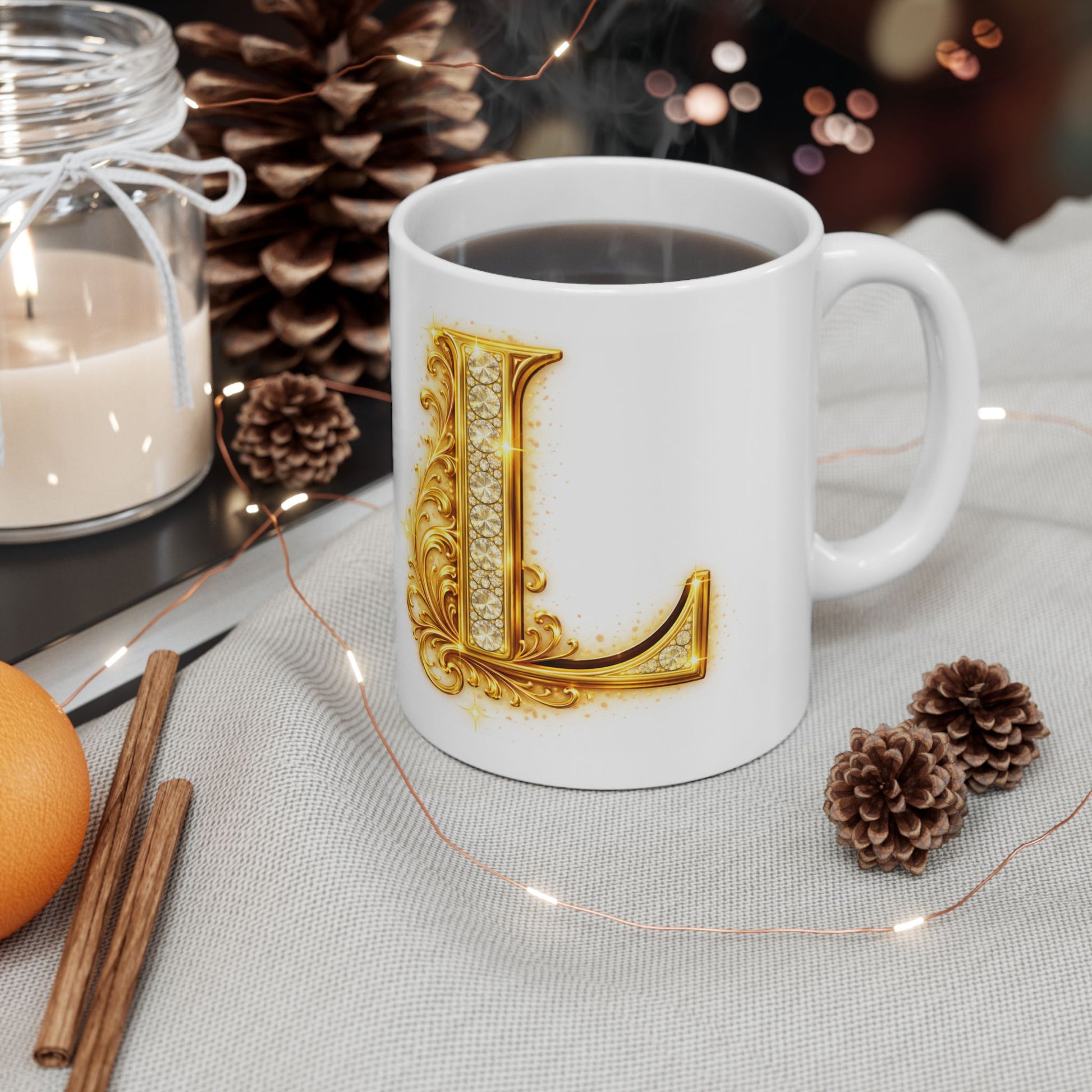 White mug with gold letter 'L' design on a table with decorative items