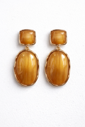 Pair of gold earrings with large, oval-shaped brown stones on a white background