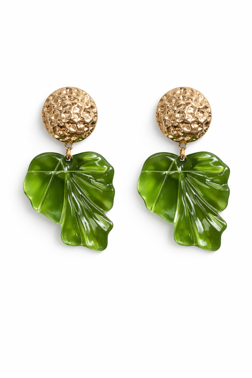 Woman wearing green leaf-shaped earrings with a plain background