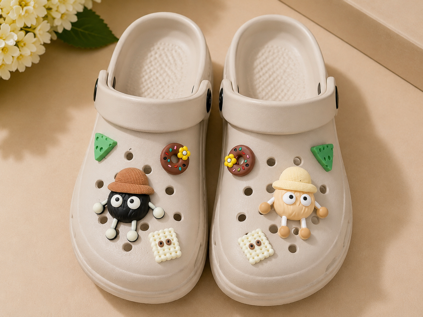 Beige clogs with decorative charms on a beige surface