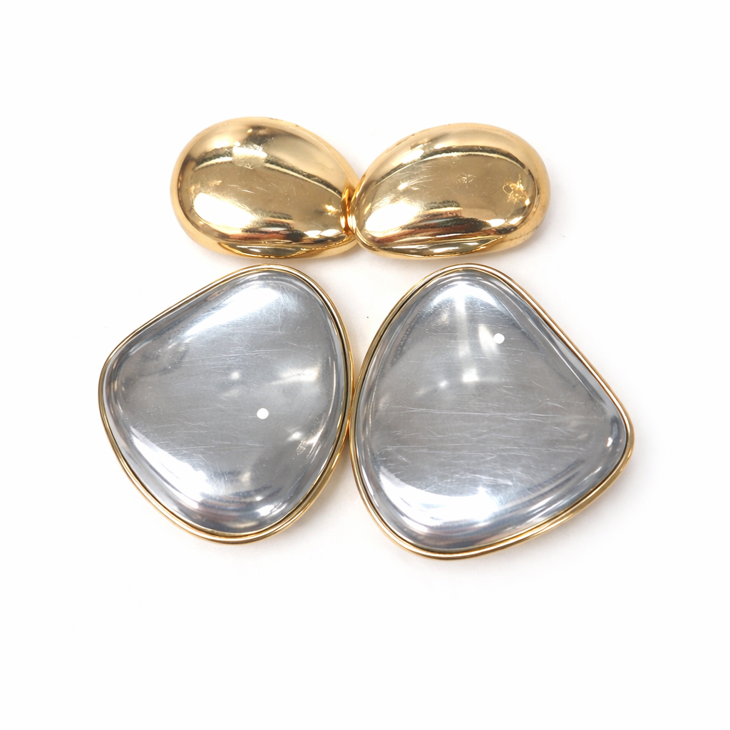 Gold and silver teardrop-shaped earrings on a white background