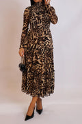 Woman wearing a leopard print dress against a plain background
