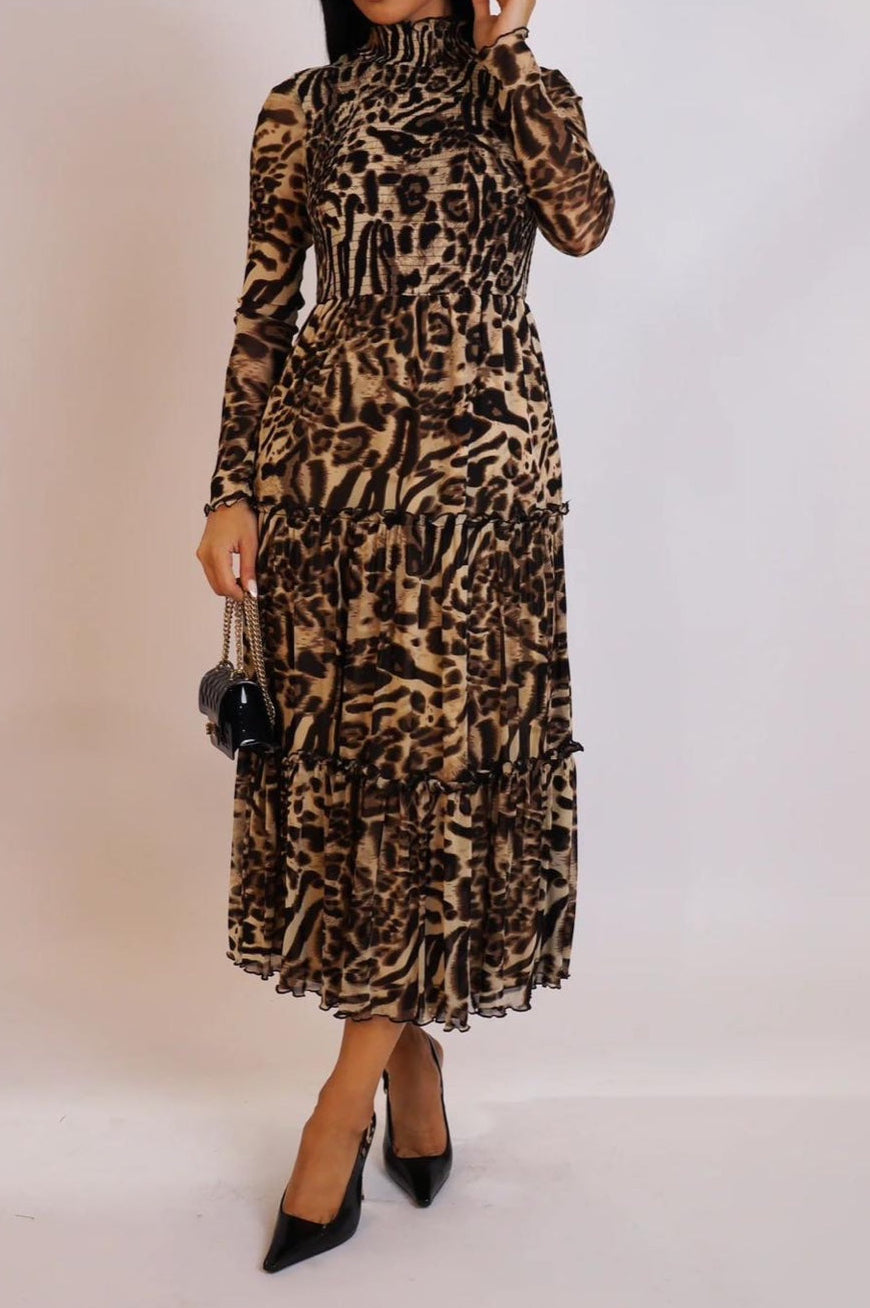 Woman wearing a leopard print dress against a plain background