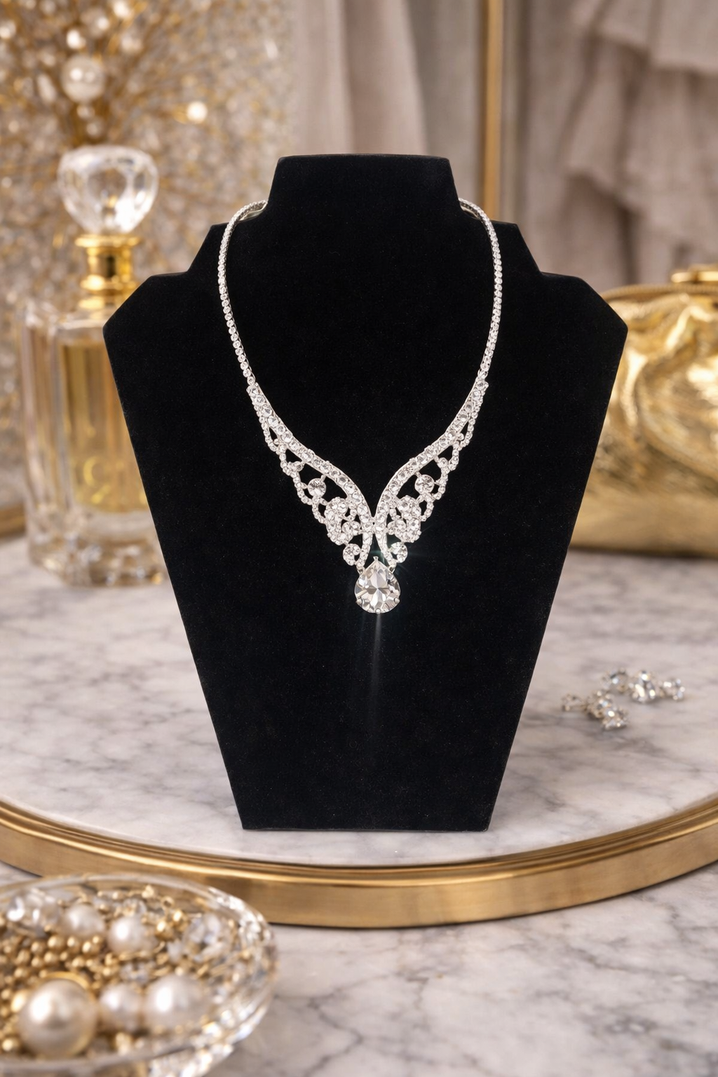 Silver necklace on a black velvet stand with decorative background