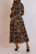 Woman wearing a leopard print dress against a plain background