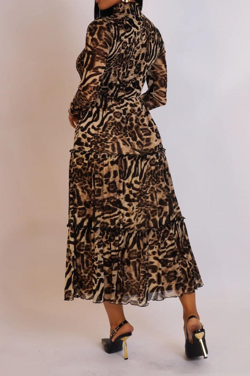 Woman wearing a leopard print dress against a plain background
