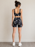 Woman wearing a black and white patterned athletic outfit on a plain background