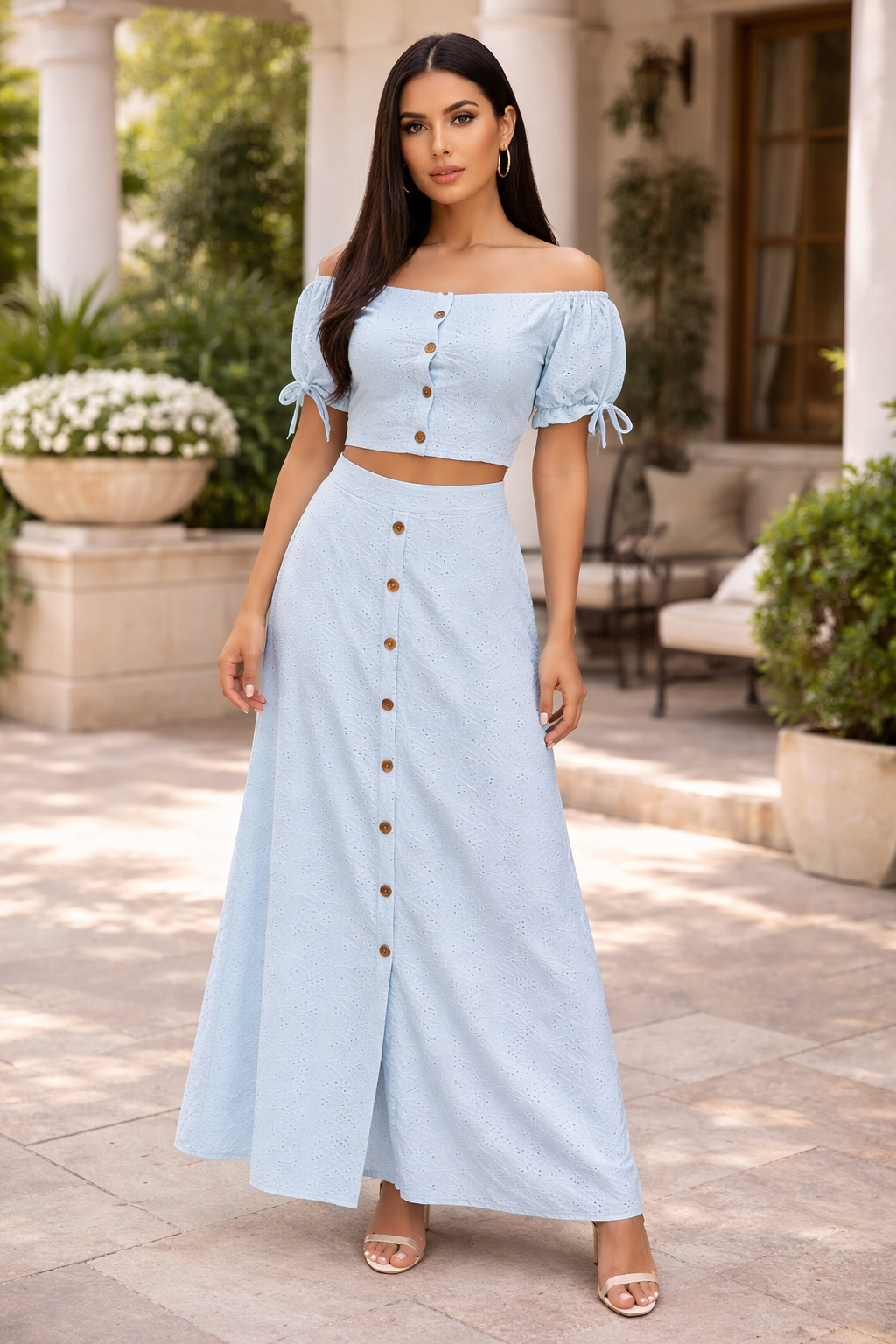 Woman wearing a light blue off-shoulder top and long skirt with buttons outdoors