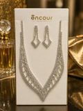 Silver necklace and earrings set on a 'encour' branded card with a gold background.