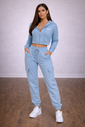 Woman wearing a light blue tracksuit with a white background