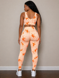 Woman wearing a peach and orange tie-dye athletic outfit against a beige wall.