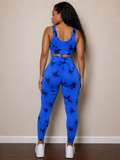 Person wearing a blue athletic outfit with black patterns against a beige wall.