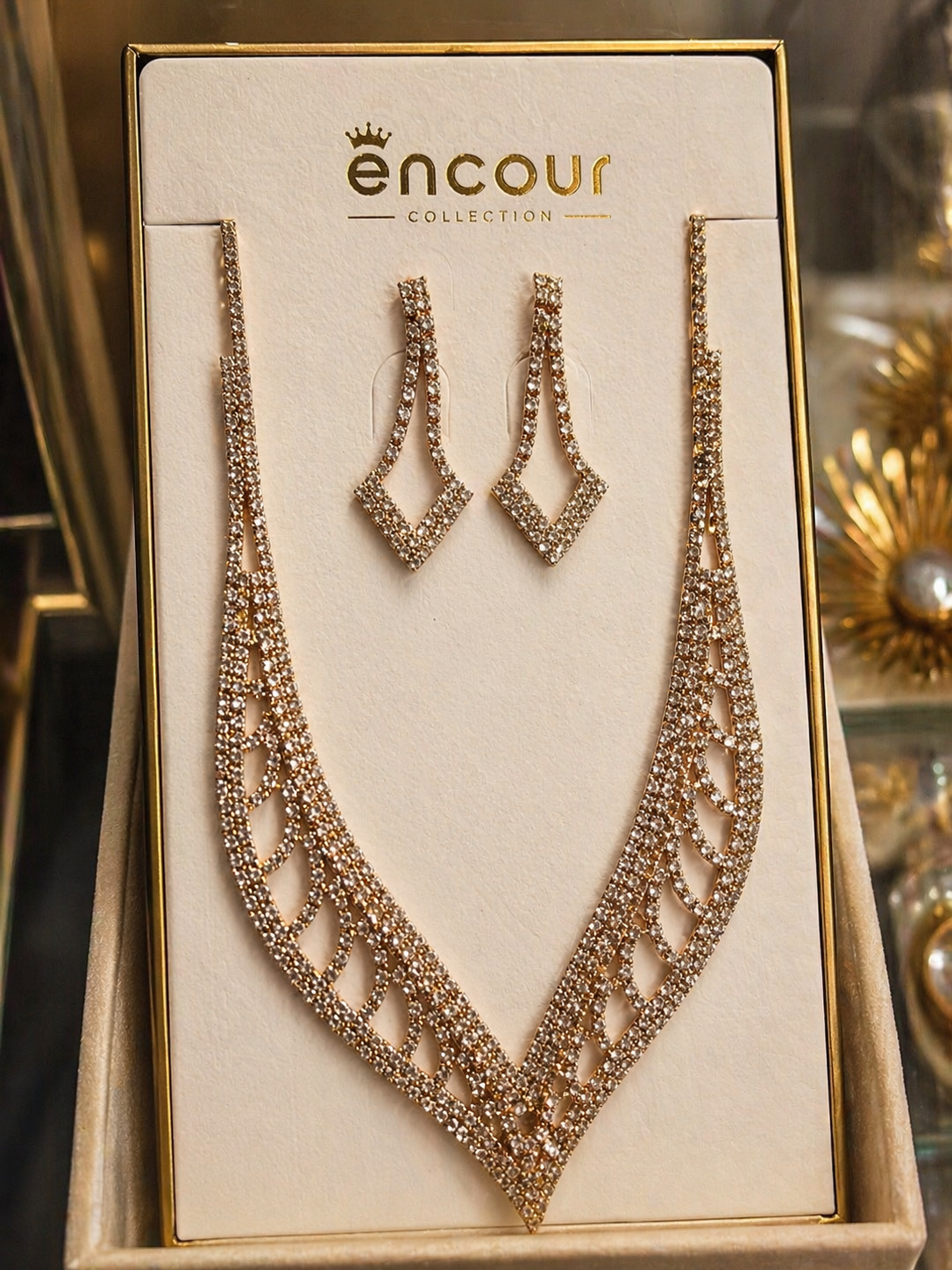 Necklace and earrings set on a 'encour' branded display card.