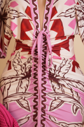 Close-up of a ruched wrap dress featuring a pink, red, and white floral print with a central tie closure.