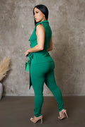 Woman wearing a green outfit against a textured wall.