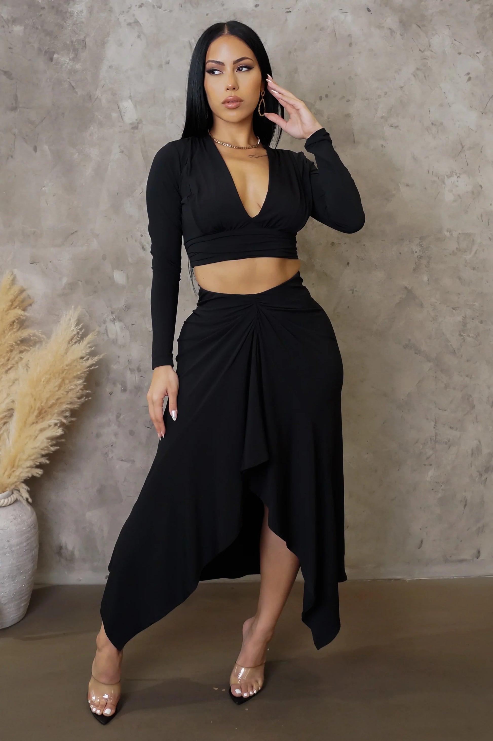 Woman wearing a black outfit against a neutral background