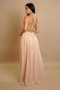 Woman wearing a long, flowing dress with a beige background