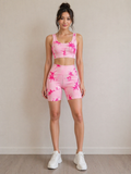 Woman wearing a pink tie-dye athletic outfit against a plain background