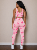 Person wearing a pink tie-dye athletic outfit against a beige wall.
