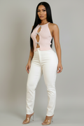 Model wearing a blush pink bow-detail cutout knit top with white high-waisted pants