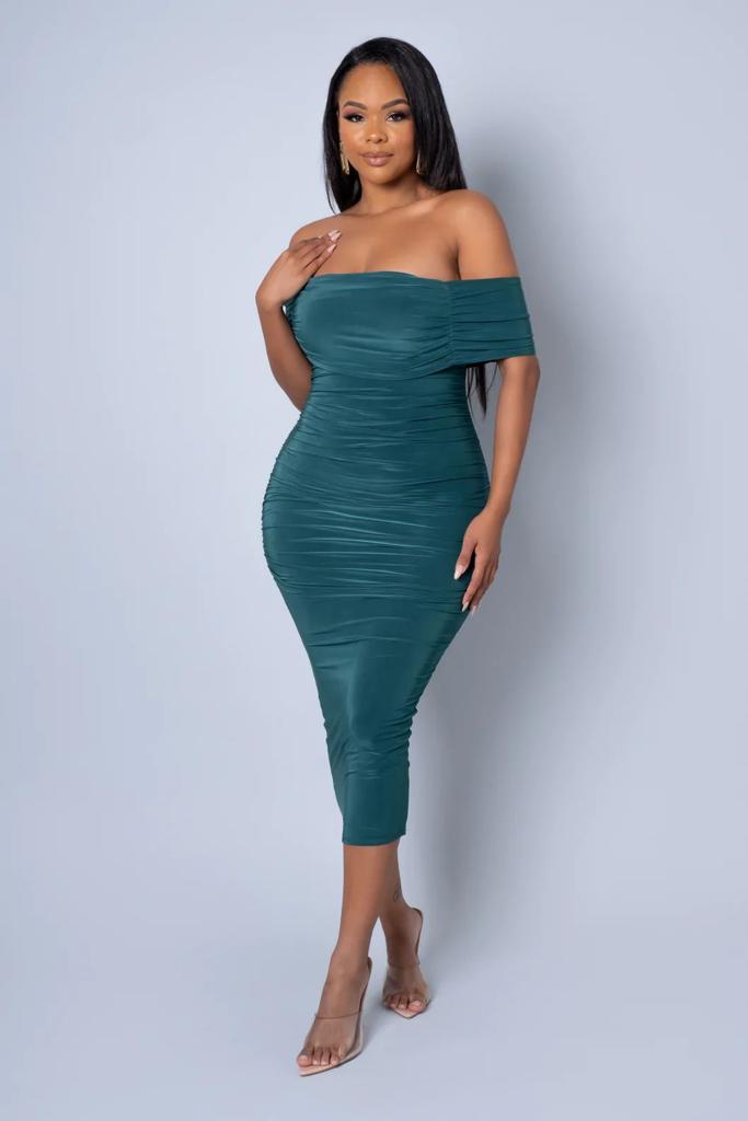 Woman wearing a teal off-shoulder dress against a light gray background