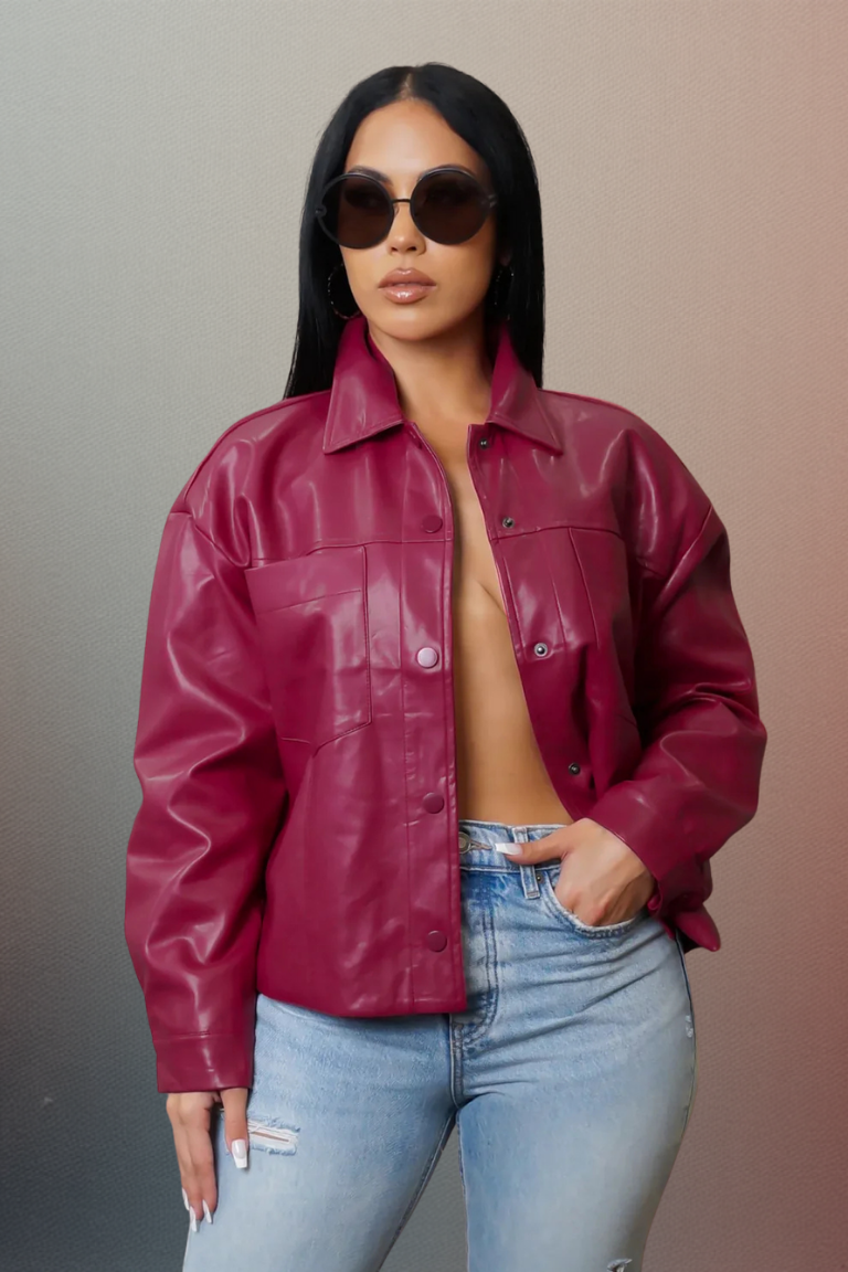 Woman wearing a red leather jacket and light blue jeans against a gradient background